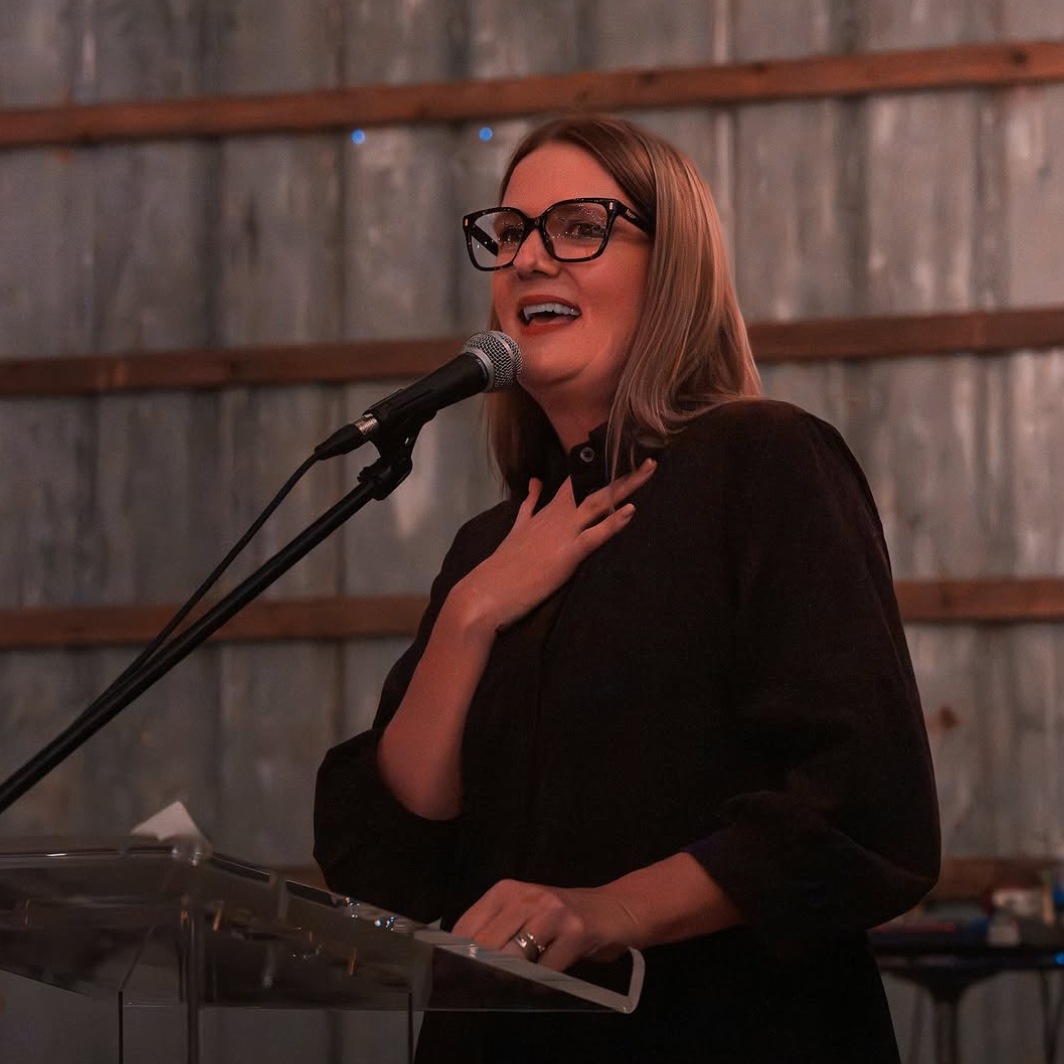 A woman speaking at a community Farmbox event in the Fraser Valley, sharing the mission of supporting local farmers and sustainable food systems.
